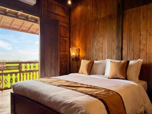 a bedroom with a bed with a wooden wall at Kalyana Gangga in Krambitan