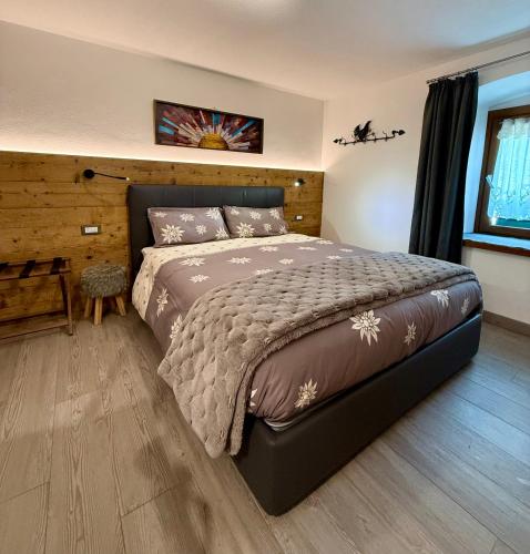 a bedroom with a large bed and a wooden floor at B&B Ciesa la Vèrda in Rocca Pietore
