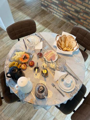 a table with food and a plate of food on it at Pousada Jardins da Gastehaus in Triunfo