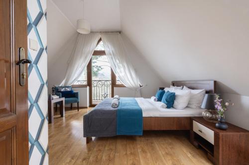 a bedroom with a bed with blue and white pillows at Wilcznik 10 in Zakopane
