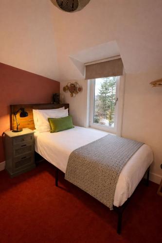 a bedroom with a large bed and a window at Lamont Cottage in Inverness