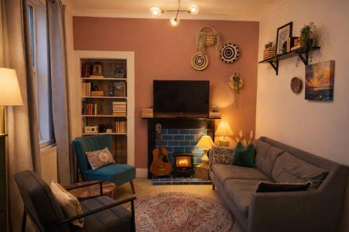 a living room with a couch and a fireplace at Lamont Cottage in Inverness
