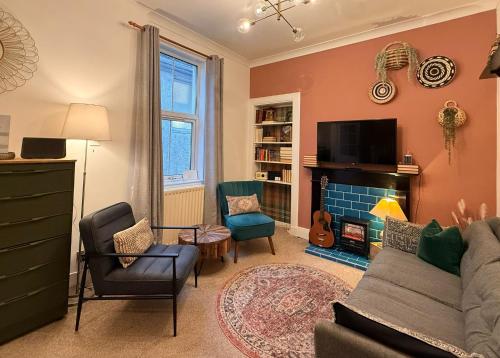a living room with a couch and a fireplace at Lamont Cottage in Inverness
