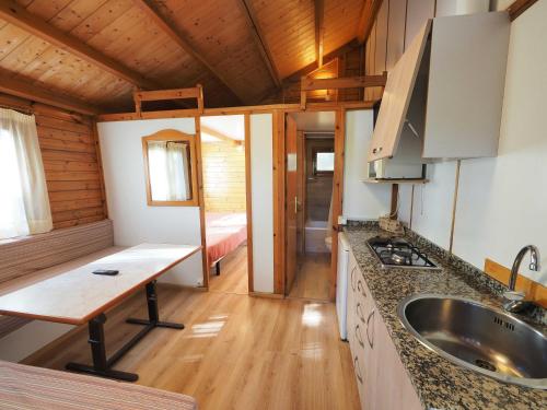 a kitchen in a log cabin with a sink at Bungalows Peña Montañesa in Aínsa