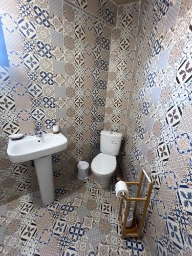 a bathroom with a white toilet and a sink at Moon Surf in Imsouane