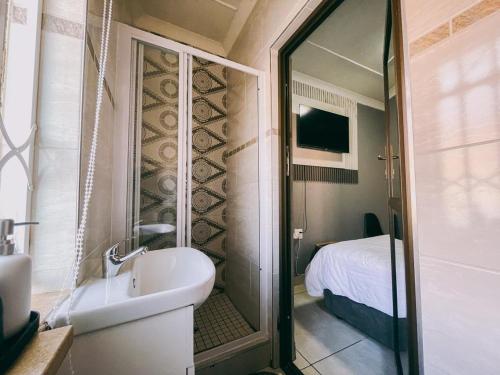 a bathroom with a tub and a sink and a bed at Lodge36 in Vanderbijlpark