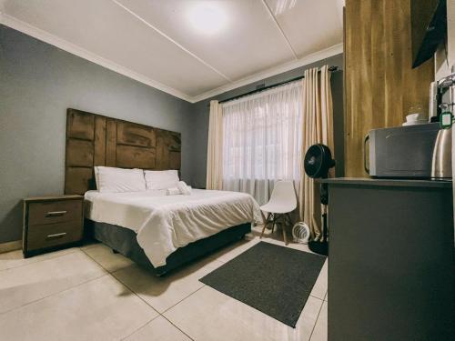 a bedroom with a bed and a tv in it at Lodge36 in Vanderbijlpark