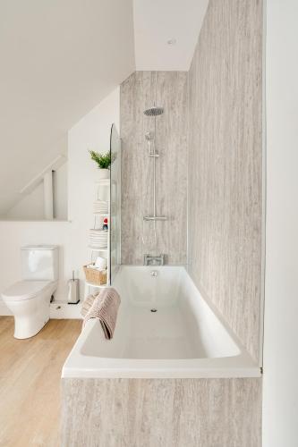 a white bath tub in a bathroom with a toilet at Apt 3 Armatage Flats, Eyemouth in Eyemouth