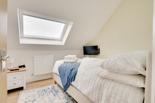 a white bedroom with a bed and a window at Apt 3 Armatage Flats, Eyemouth in Eyemouth