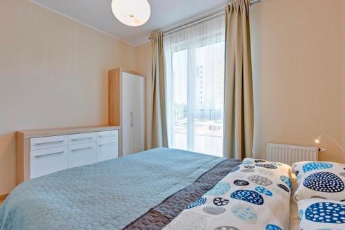 a bedroom with a bed and a large window at Flatbook - Seaside Apartments Tre Mare II in Gdańsk