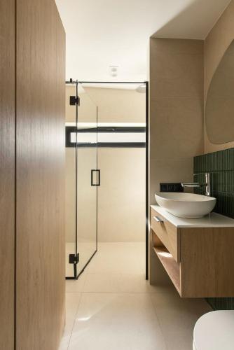 a bathroom with a sink and a glass door at Ґонт - затишний будинок з чаном біля Буковелю in Tatariv