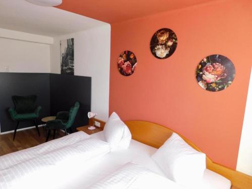 a bedroom with an orange wall with a bed and plates on the wall at OhneTamTam in Ehrenhausen