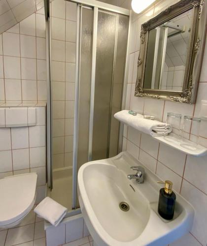 a white bathroom with a sink and a shower at OhneTamTam in Ehrenhausen