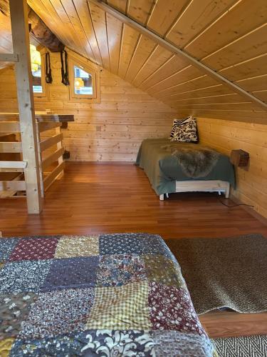 a room with a bed in a wooden cabin at Mayen unique et authentique in Vernamiège