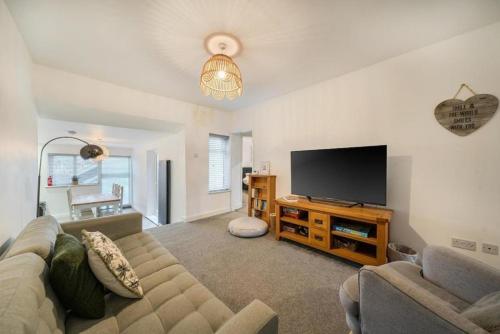 a living room with a couch and a flat screen tv at Spacious Three Bedroom Flat in Filey Town Centre with Workspace in Filey