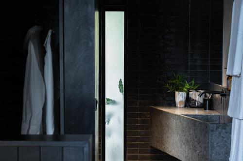 un bagno con doccia e un bancone con lavandino di Silverback Lodge a Buhoma