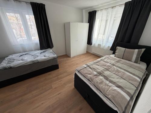 a bedroom with two beds and two windows at Ferienhaus Fünf Täler in Geislingen an der Steige
