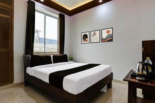 a bedroom with a large bed and a window at HOTEL O MJ INN in Darbhanga