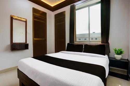 a bedroom with a large bed and a window at HOTEL O MJ INN in Darbhanga