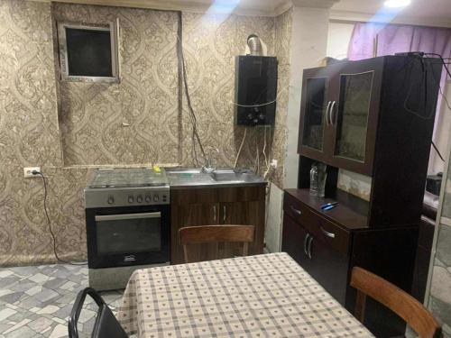 a kitchen with a sink and a stove and a table at Village house in Telavi