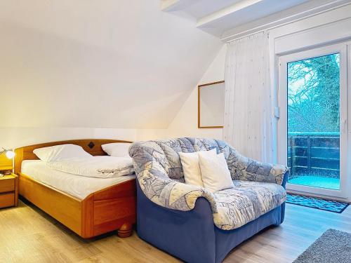 a bedroom with a bed and a chair and a window at Zaunkönigs Nest in Böhl
