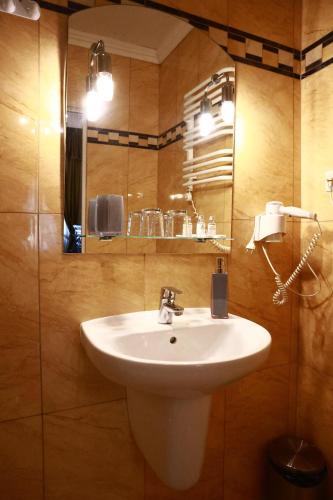 Un baño con un lavabo blanco y un espejo. en Pałac Biedrusko, en Poznan