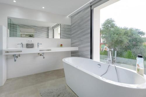 a white bathroom with a tub and a window at Fantástico in Bellavista