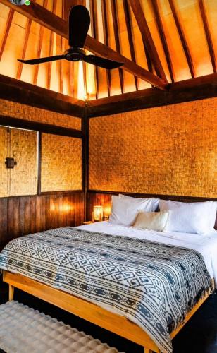 a bedroom with a large bed with a ceiling at Garden House Balangan in Uluwatu