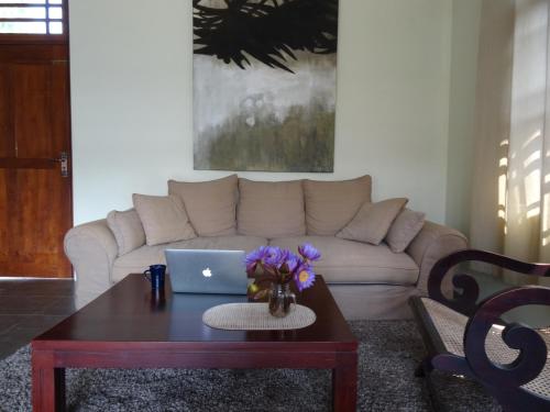 a living room with a couch and a table with a laptop at Ok Cabana Negombo in Negombo