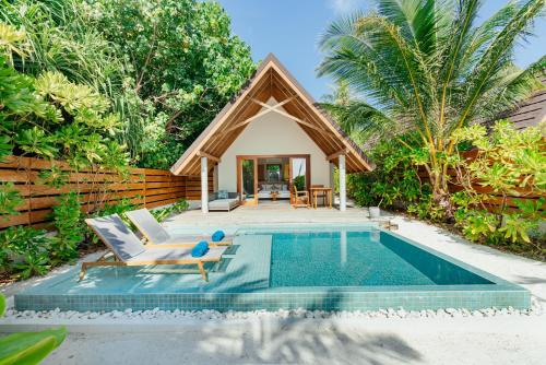 a villa with a pool and a house at Fushifaru Maldives in Fushifaru