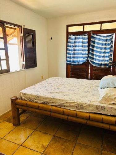 a bed in a room with two windows at TAIBA - ONDAS DO MAR RESIDENCE Ap 212 - Rezende Temporada in São Gonçalo do Amarante
