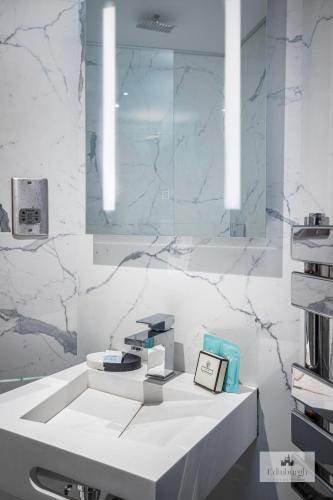 a bathroom with a white counter and marble walls at 2Bedroom apartment by the castle in Edinburgh