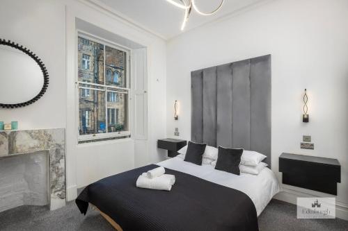 a bedroom with a large bed and a fireplace at 2Bedroom apartment by the castle in Edinburgh