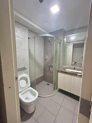 a bathroom with a shower and a toilet and a sink at Staycation near MOA at Monarch in Manila