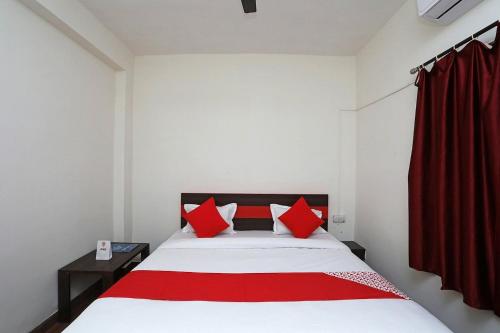 a bedroom with a bed with red pillows at Hotel Sintle Palace in Bhubaneshwar