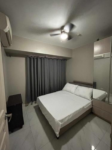 a bedroom with a bed and a ceiling fan at Staycation near MOA at Monarch in Manila