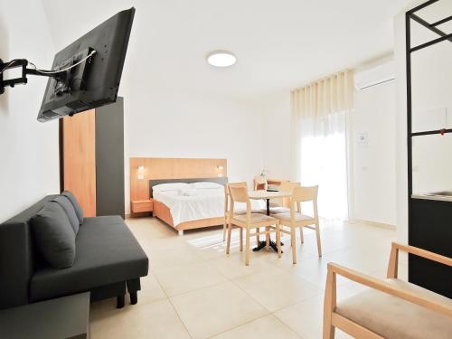 a living room with a couch and a bed and a tv at Estelle in Bari