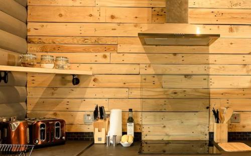 a kitchen with a wooden wall with a counter top at Cateran Rest in Kirkmichael