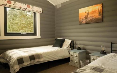 a bedroom with two beds and a window at Cateran Rest in Kirkmichael
