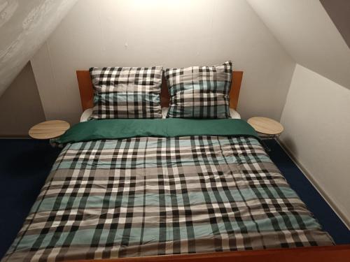 a bedroom with a bed with plaid sheets and pillows at Paula Apart in Wadowice