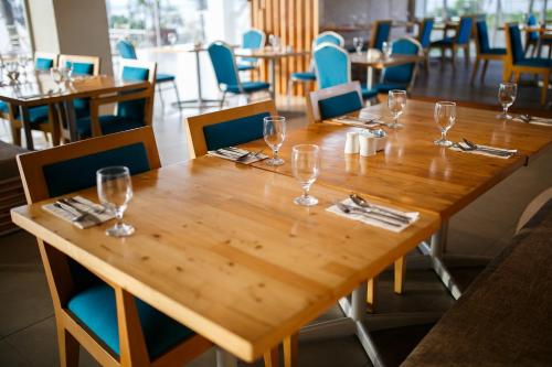 a wooden table with wine glasses on it in a restaurant at Solea Mactan Resort in Mactan
