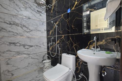 a black and white bathroom with a sink and a toilet at Forest Nest Farm Stay in Rājpur