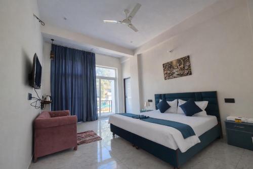 a bedroom with a large bed and a chair at Forest Nest Farm Stay in Rājpur