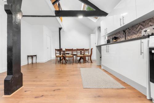 a kitchen and dining room with white walls and wooden floors at The Old Band Room House No 1 in Blaina