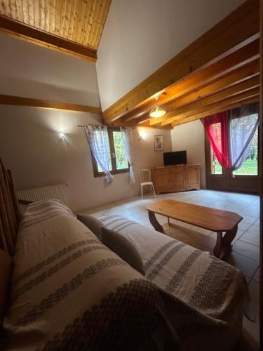 a living room with two beds and a table at Gîtes de Charme en Isère in Sonnay
