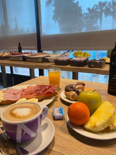 a table with plates of food and a cup of coffee at Hotelet elRetiro in Cambrils