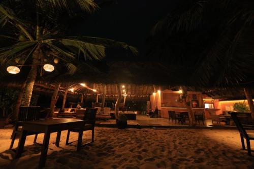 a table and chairs on a beach at night at Mangrove Beach Cabana in Tangalle