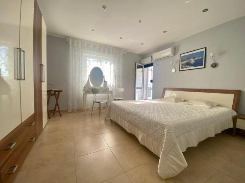 a bedroom with a bed and a table and a window at Villa Maja in Sutomore