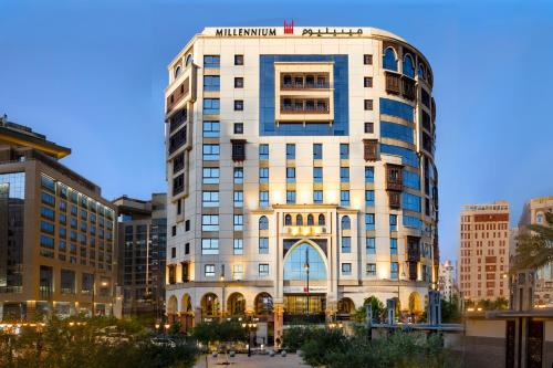 a tall white building in a city at Millennium Taiba Hotel in Medina