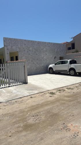 a white car parked in front of a building at Anjos in Ilha Comprida